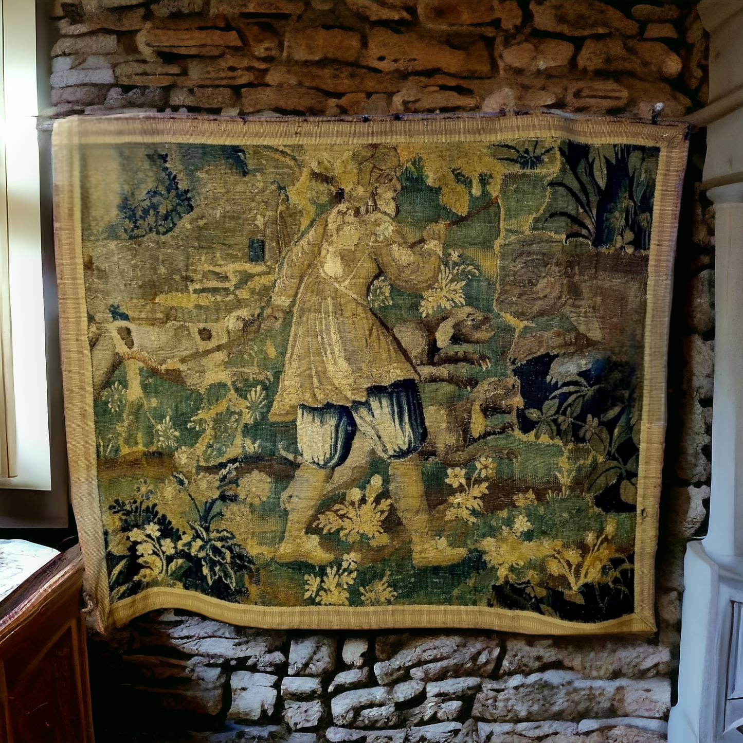 A Large 17th Century Flemish Antique Verdure Tapestry Fragment Depicting A Huntsman With Dogs And A Bear