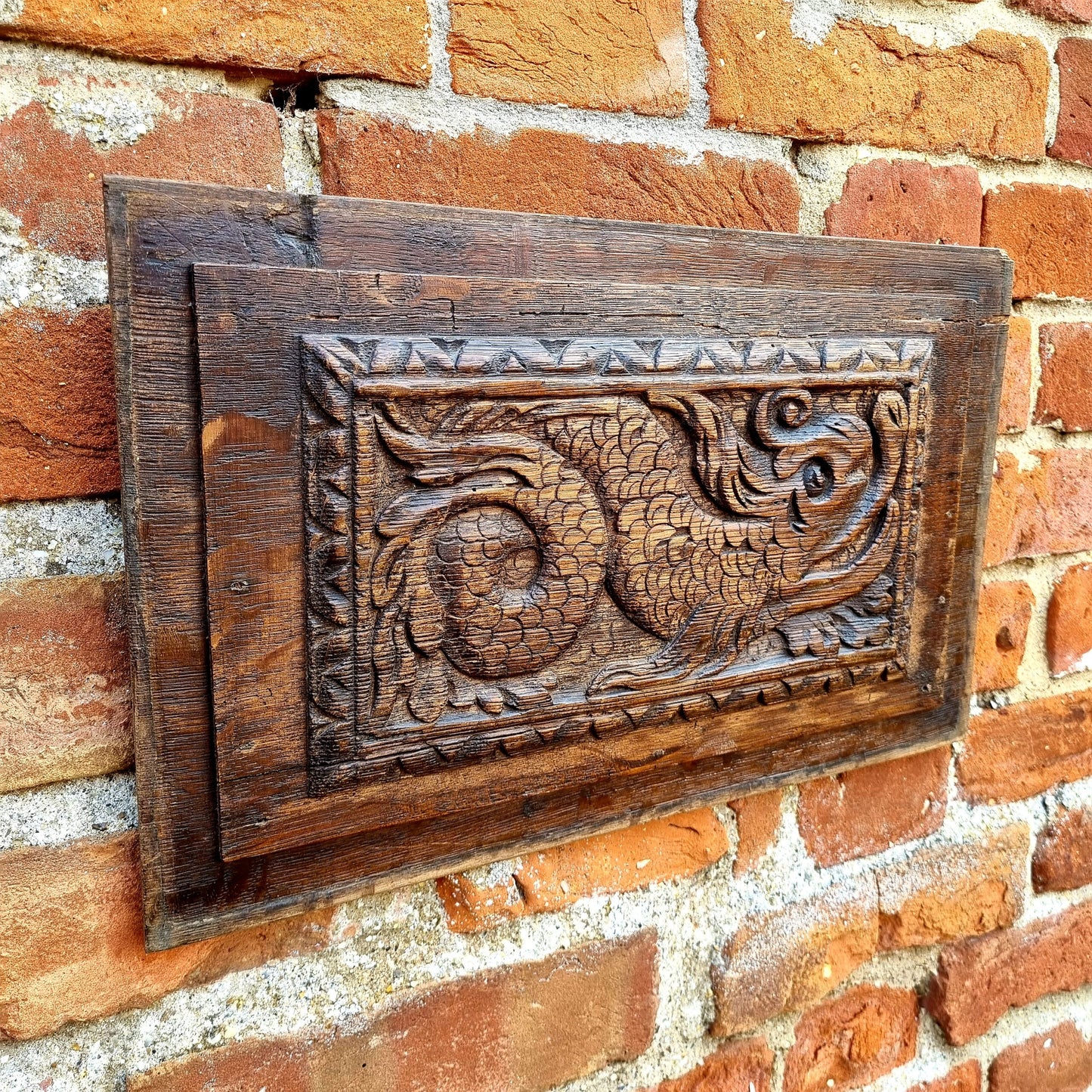 A pair of early 17thC antique carved oak panels depicting stylised mythical sea creatures