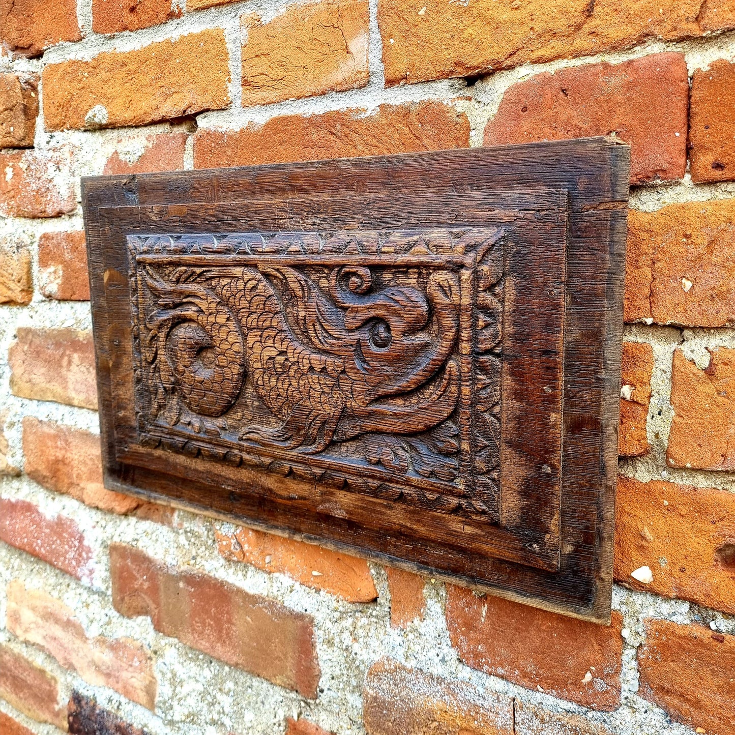 A pair of early 17thC antique carved oak panels depicting stylised mythical sea creatures