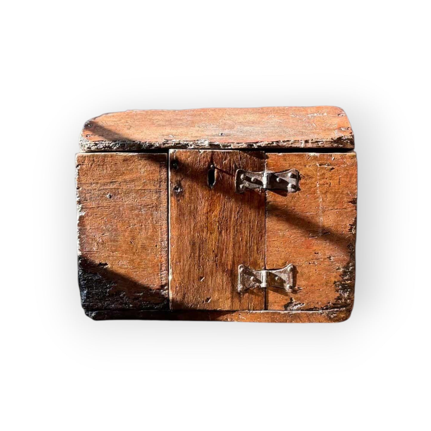 Front view of 17th century English oak poor box showing central locked door, iron escutcheon, and oak surface