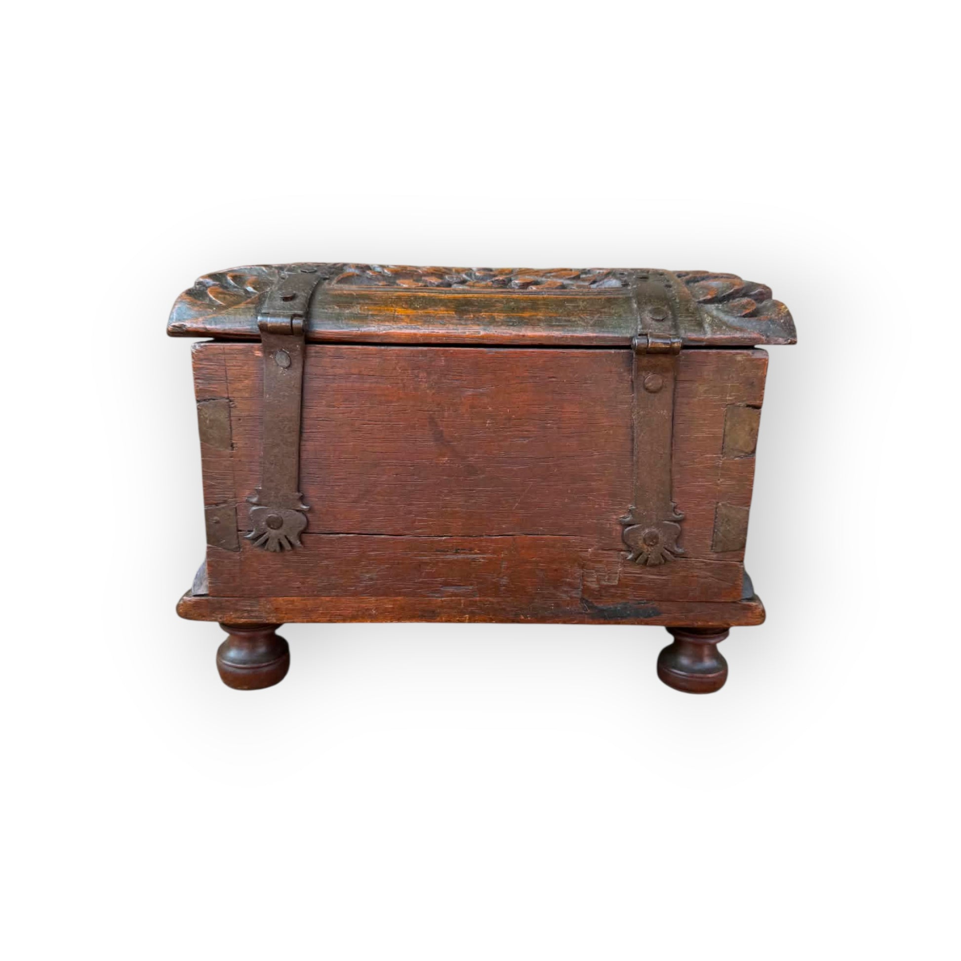 Long iron strap hinges with pierced decorative terminals riveted over lid of 17th century carved oak table casket