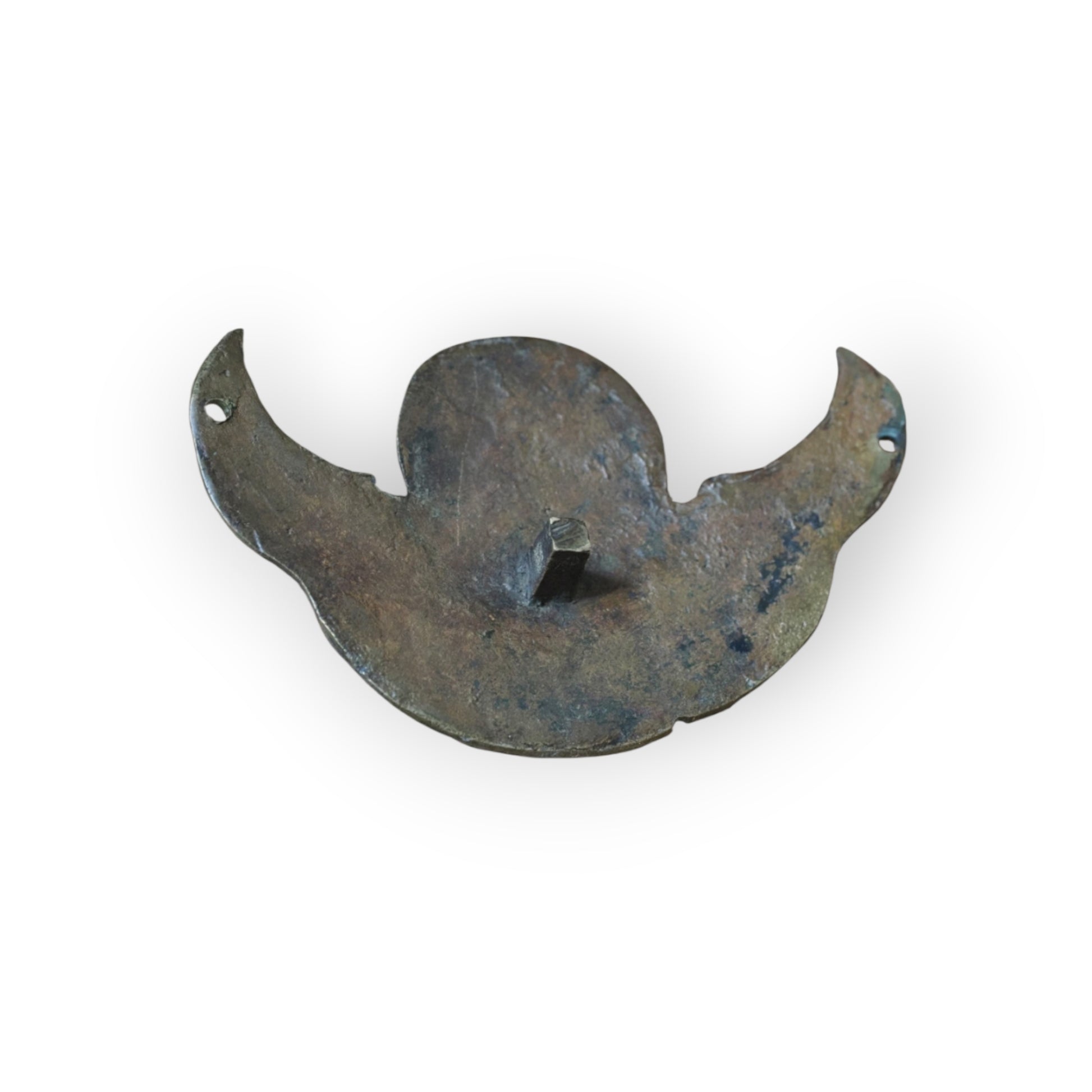 Reverse of Renaissance brass cherub appliqué showing original integral square-section fixing tang and pierced wing-tips.