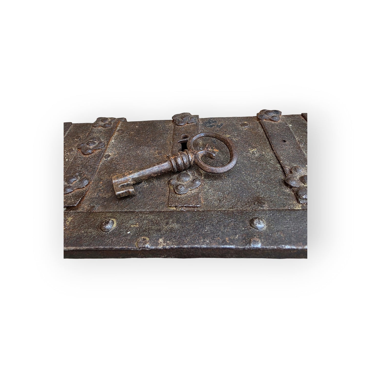Close-up of the original iron key engaged in the lock to the top of the casket