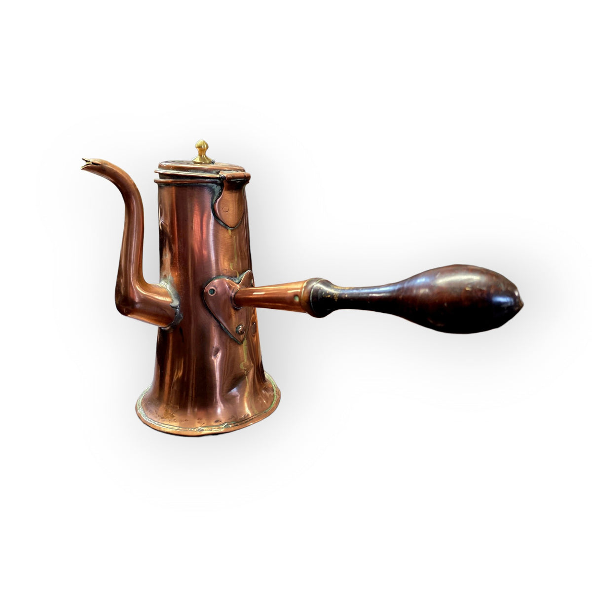 Side profile of an 18th century copper side-handled coffee pot showing the hand-raised tapering body and turned wooden handle.