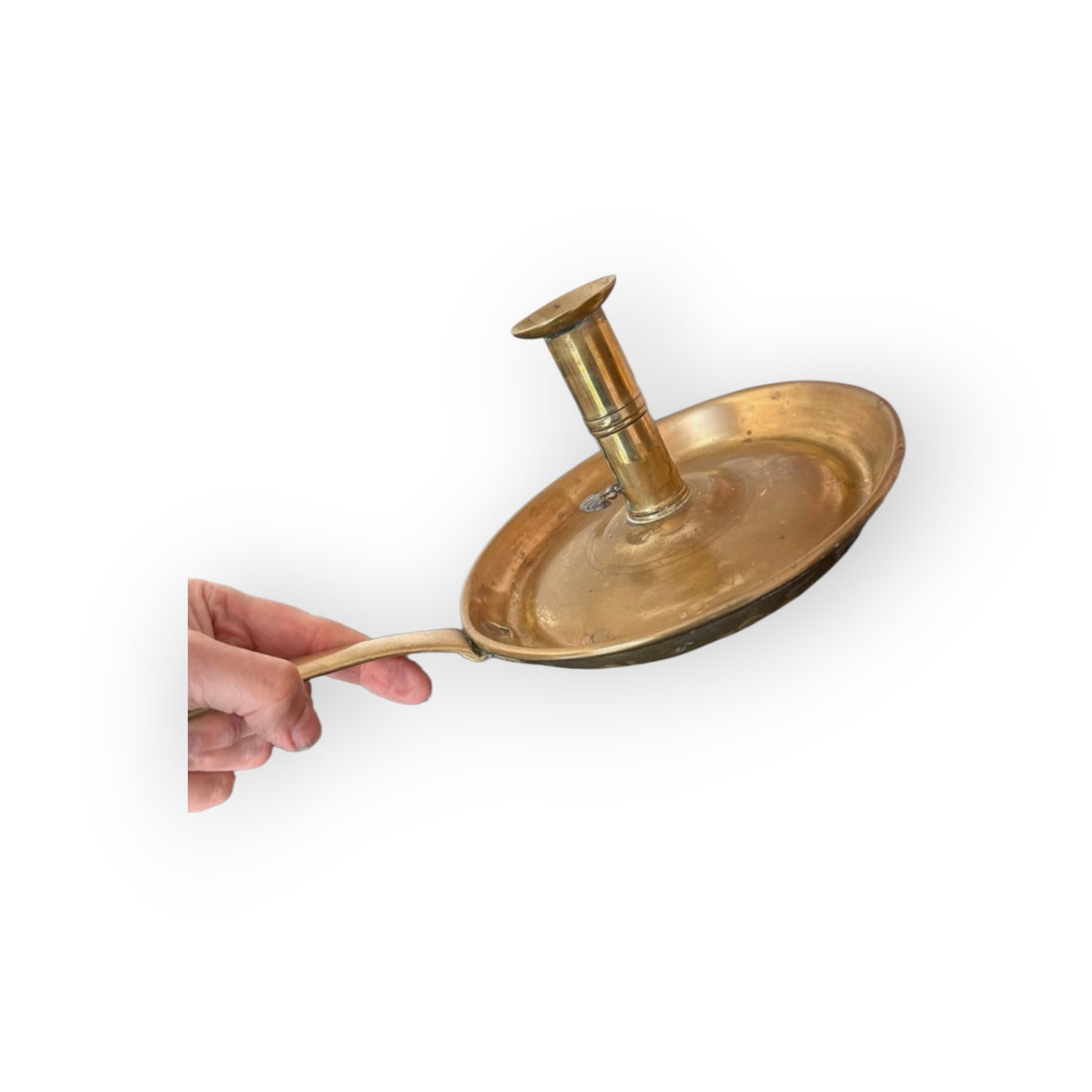 Georgian brass chamberstick held by hand showing dished drip pan and flat tapering handle
