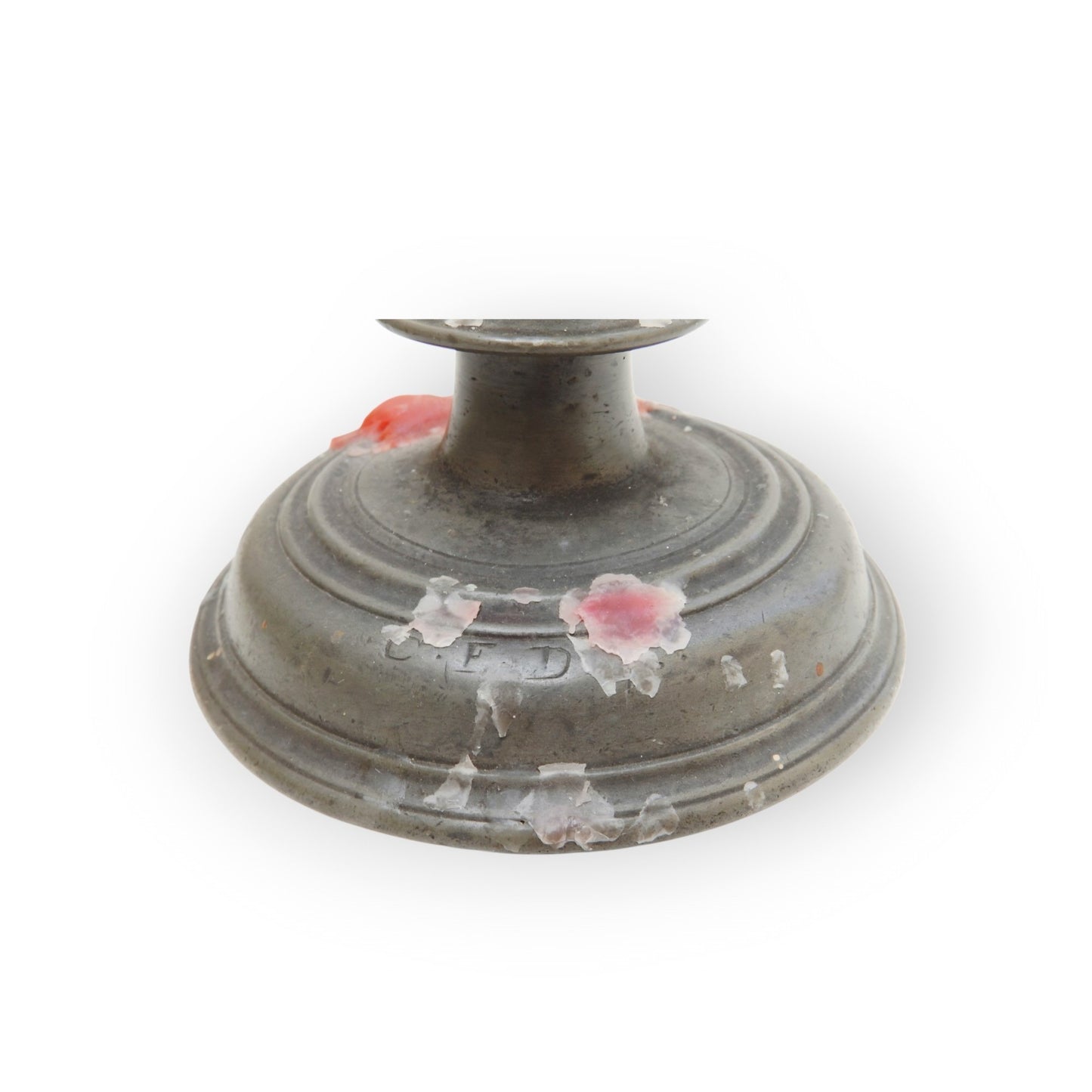 Detail of the stepped base skirt of the pewter candlestick, showing a partial owners mark and red wax spots
