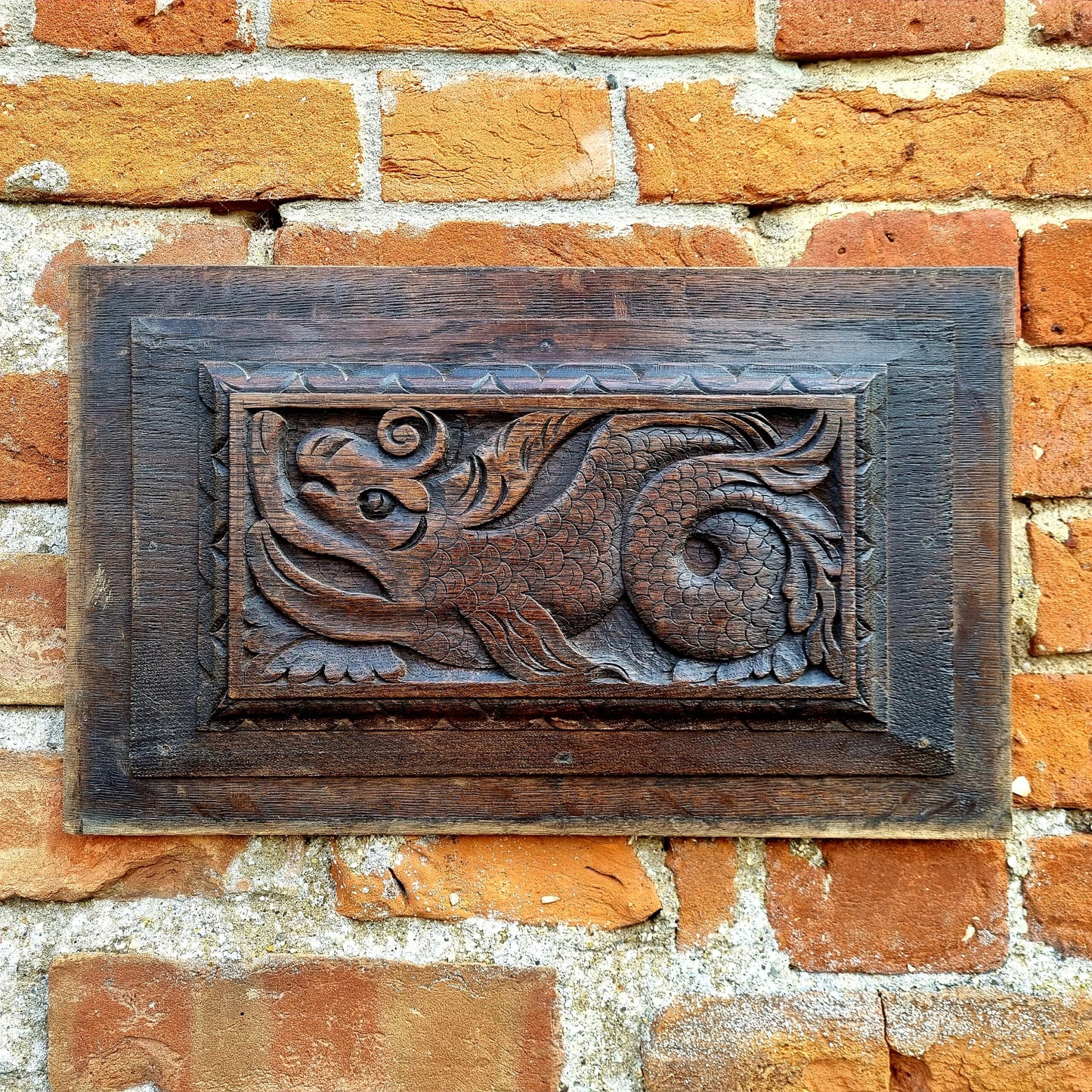 A pair of early 17thC antique carved oak panels depicting stylised mythical sea creatures
