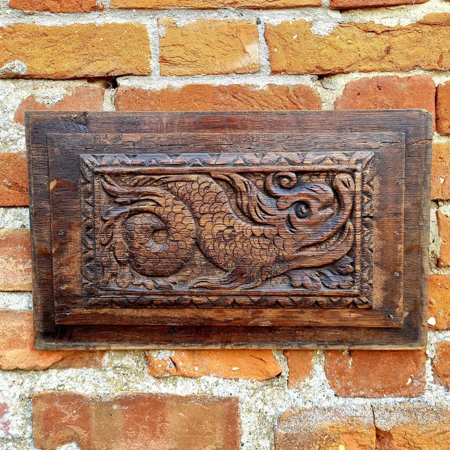 A pair of early 17thC antique carved oak panels depicting stylised mythical sea creatures